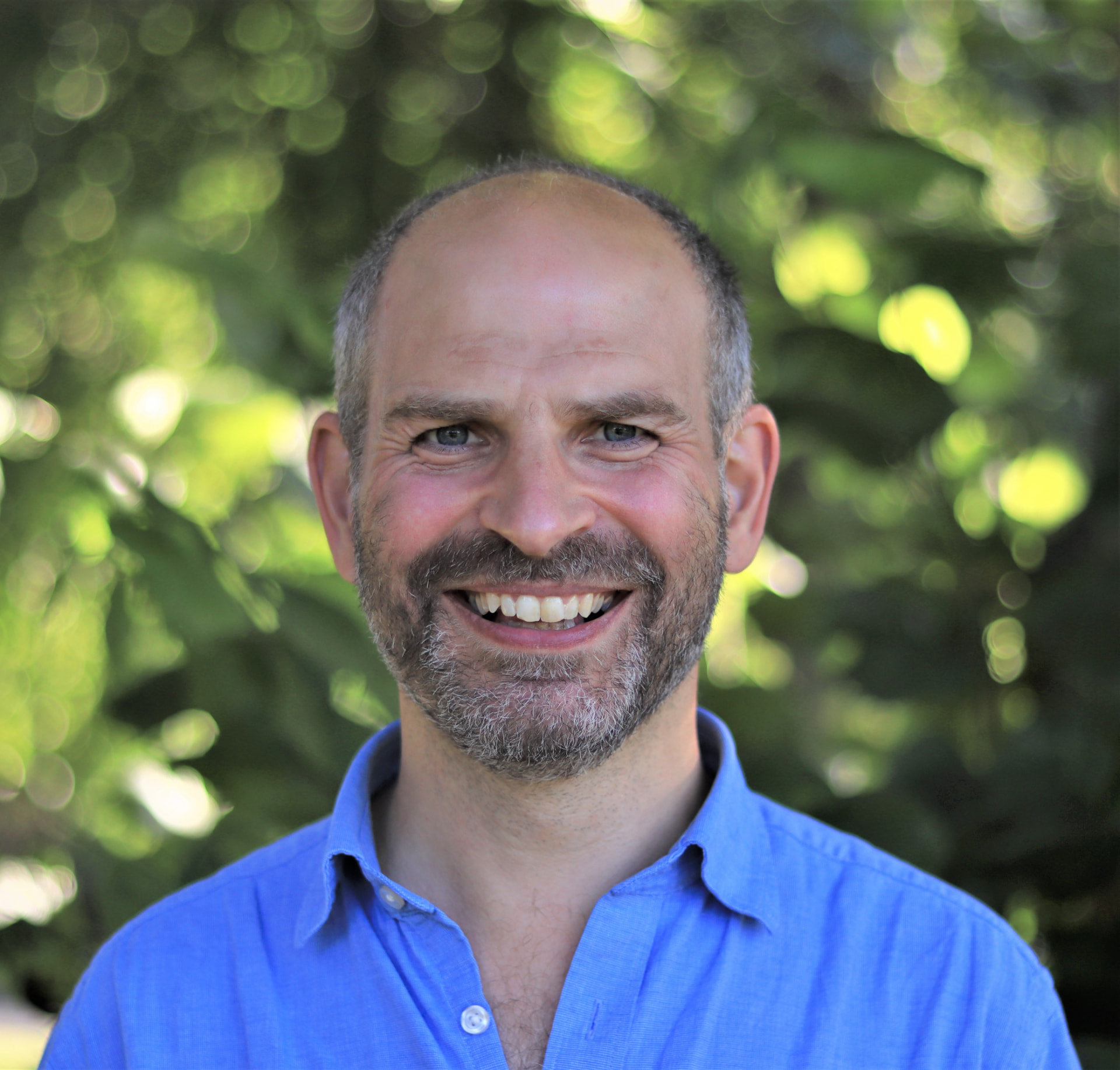 Dave Hill, founder of Simplicity in Mind, smiling outdoors in a blue shirt